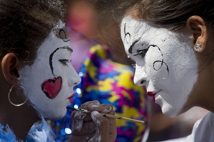 A woman paints a girl's face during an anti-government march organized by women's rights organizations to commemorate International Women's Day in Managua, Nicaragua, Sunday, March 8, 2015. (AP Photo/Esteban Felix)